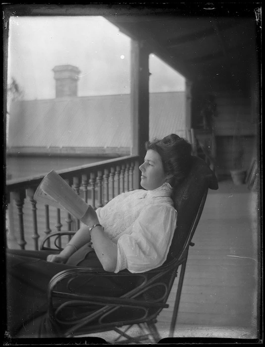 Unidentified woman sitting in a chair reading a book