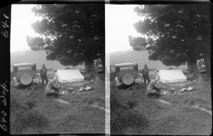 Edgar Williams by campfire and unidentified man by tent, unknown location