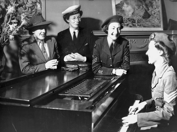 Unidentified group of women wearing World War II military uniforms, around a piano