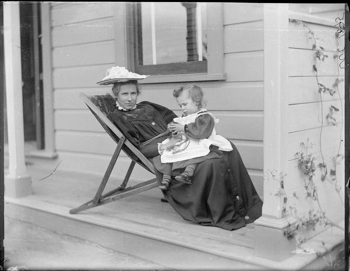 Lydia Williams, with a child, possibly her son Owen William Williams, sitting on her porch, Royal Terrace, Kew, Dunedin