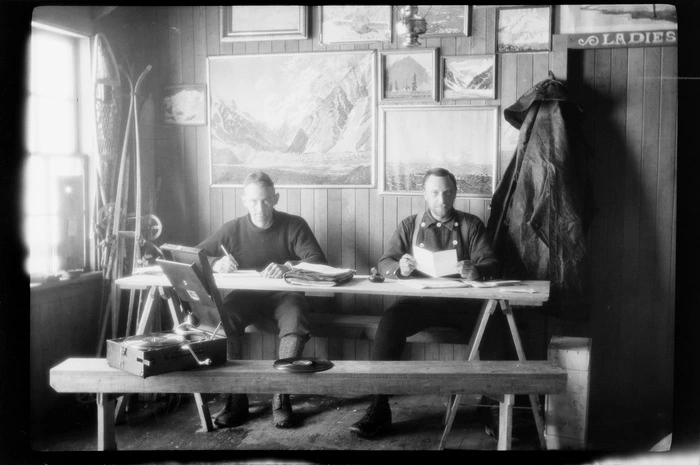Interior of Ball Hut, with two unidentified men sitting at table, Mount Cook National Park, Canterbury Region