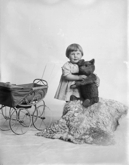 Young girl with a pram and a teddy bear