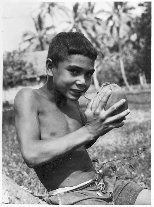 Unidentified boy husking a coconut, Cook Islands