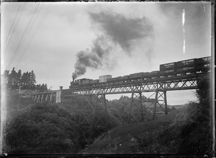 A goods train crossing an unidentified viaduct