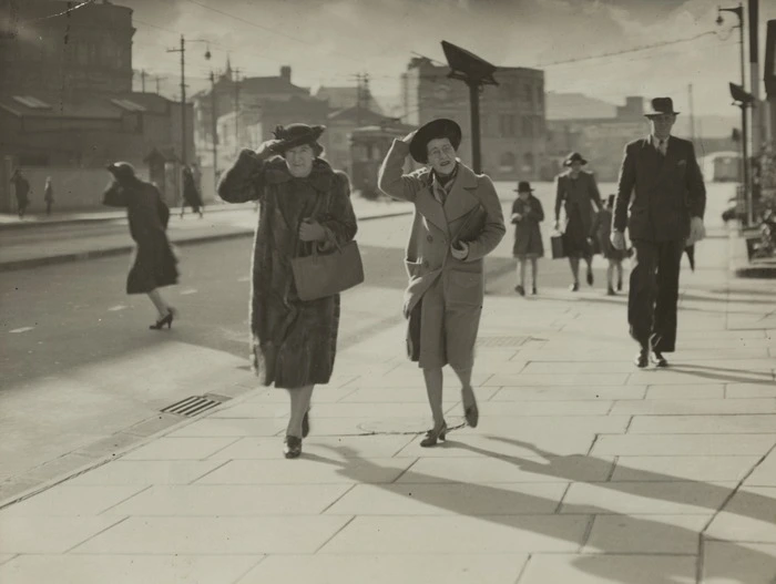 Women holding on to their hats during a windy day, Thorndon Quay, Wellington - Photograph taken by C P S Boyer