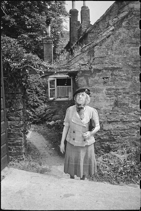 Frances Hodgkins outside a cottage in Corfe Castle village, Dorset