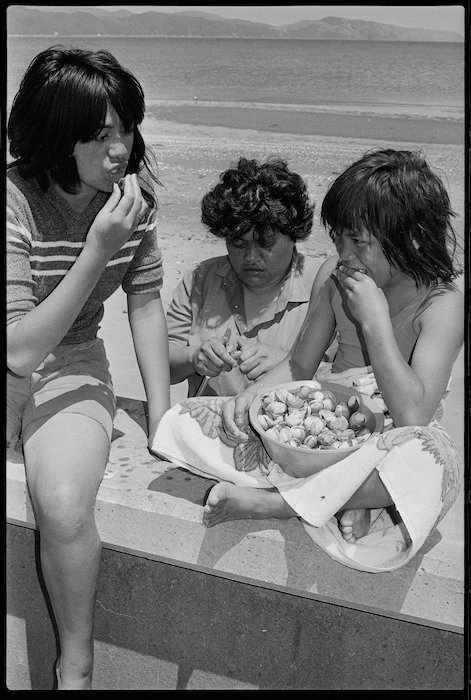 Three children eating pipi on Petone Beach