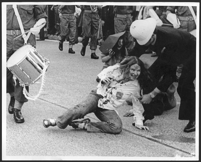 Woman demonstrator being dragged by a policeman
