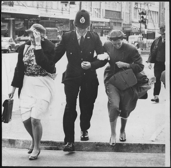 Policeman escorting two women across a street, Wellington