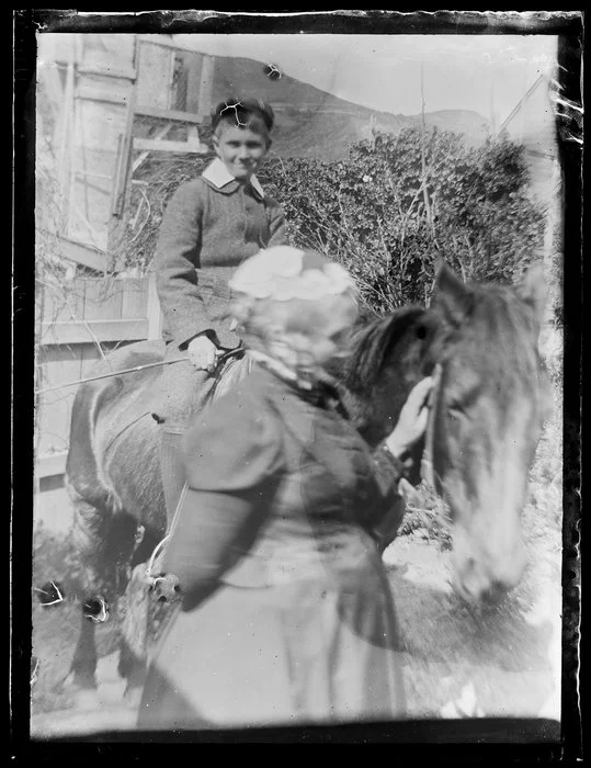 Sarah Jane Kirk standing beside a boy on a horse