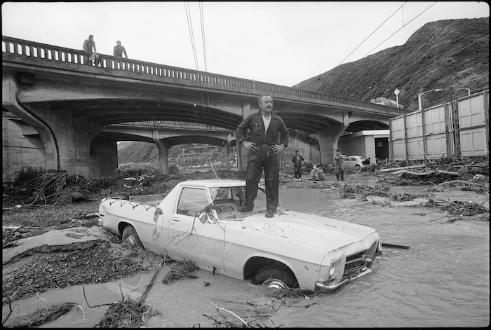 Man surveying flooding under the Petone overbridge, Wellington