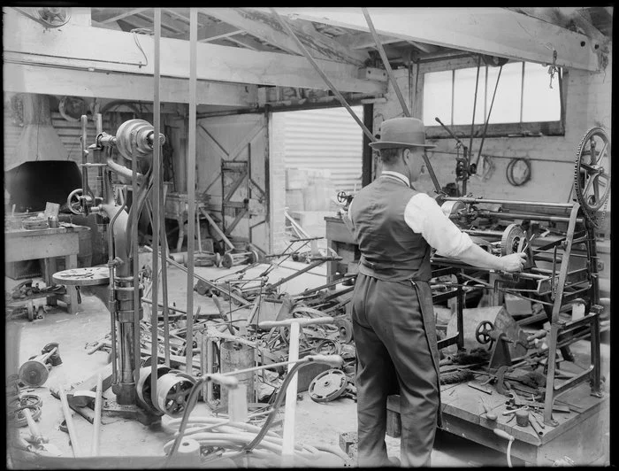 A man operating equipment in a machinery workshop, [Christchurch?]