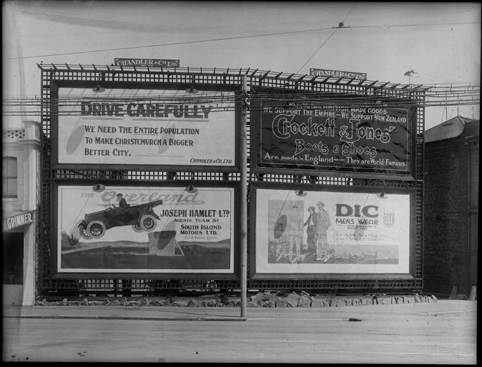 Christchurch, billboard advertisements for Crockett & Jones boots and shoes, the Overland motorcar, D.I.C. menswear, and a public safety message sponsored by Chandler & Company Ltd