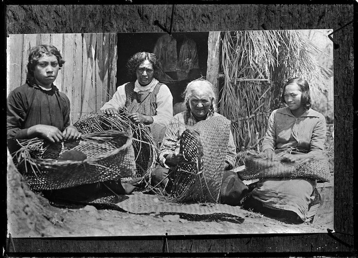 Group of Maori women weaving flax baskets (kete), at Rangiahua, 1918.