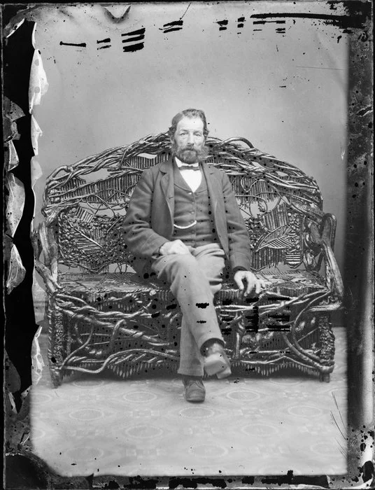 Unidentified man, seated on an ornate chair