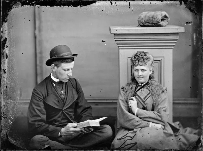 Unidentified man reading a book, and an unidentified woman