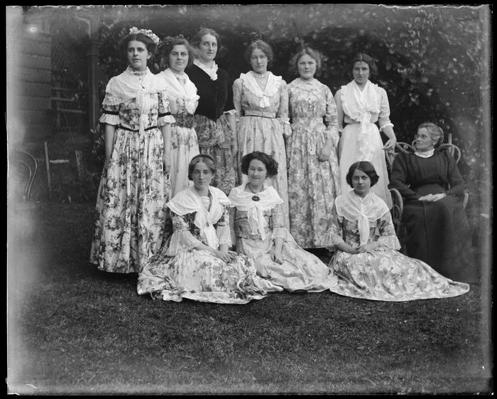 Group portrait of Cybele Ethel Kirk with nine young women wearing floral dresses with fichues