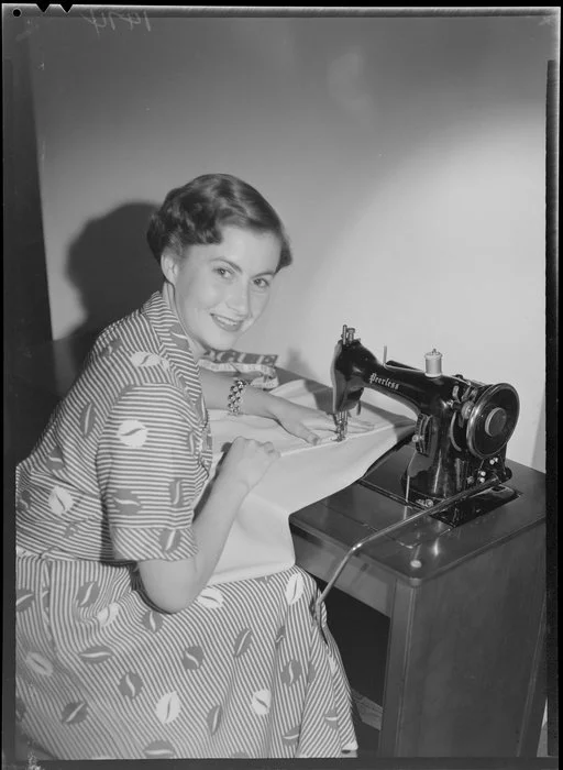 Model demonstrating Peerless sewing machine