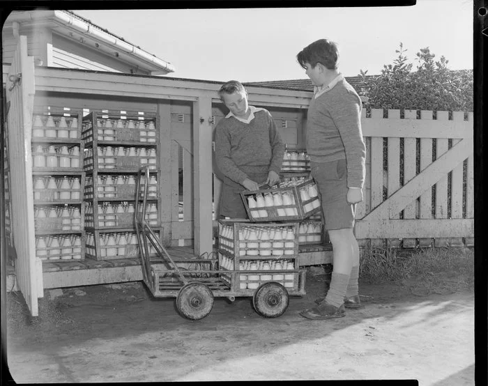 Schoolboys loading milk trolley