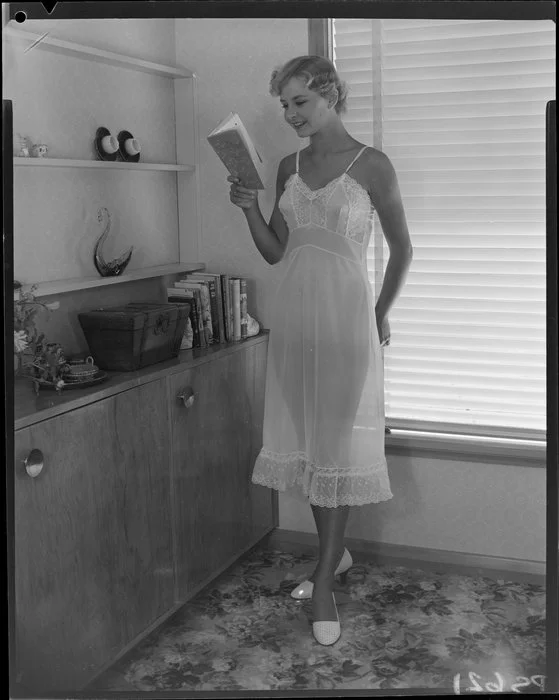 Woman in slip, reading 'The Snow Goose'