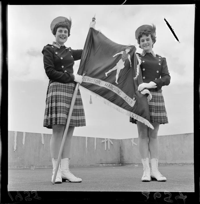 Marching girls holding a Wellington Marching Association banner