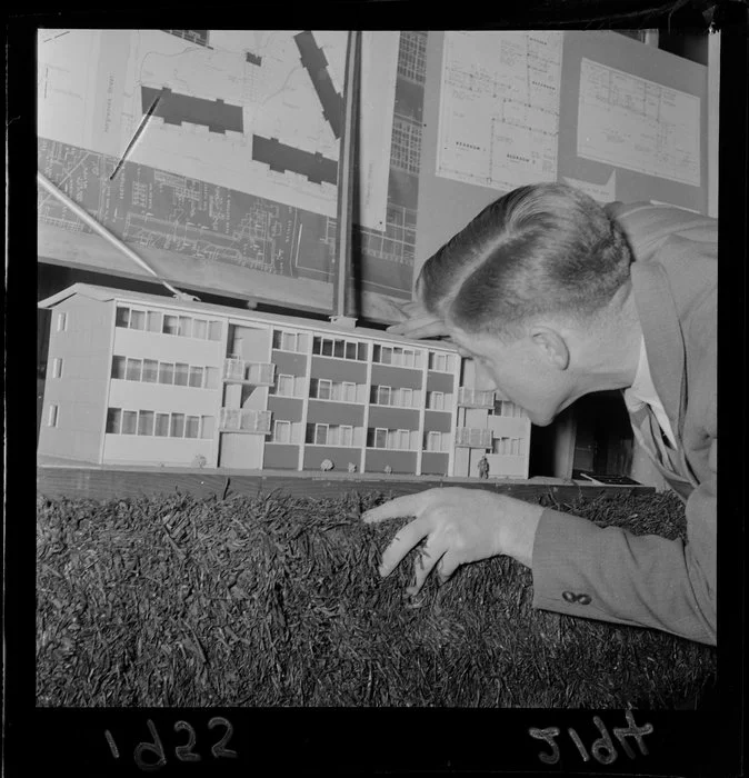 Unidentified man with architectural model, at exhibition of housing schemes, Drapery and General Importing Company of New Zealand Ltd gallery