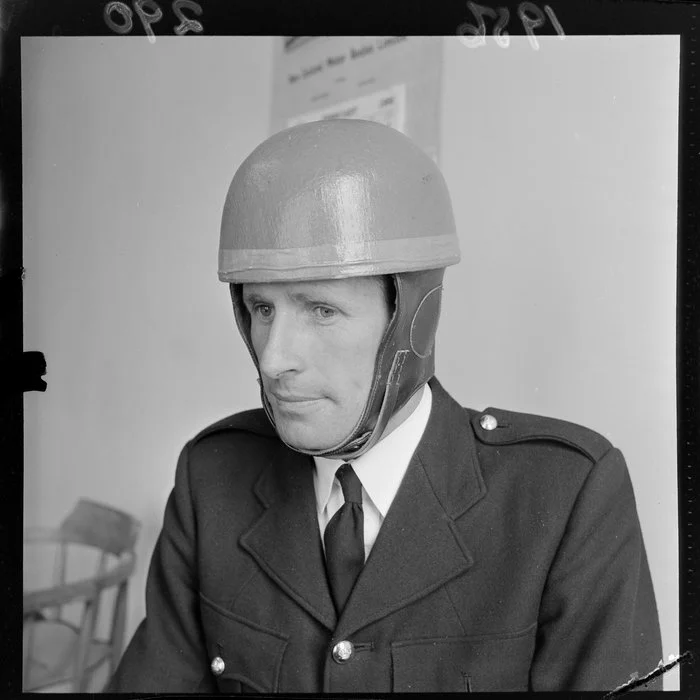 An unidentified official [policeman?] models a safety helmet at the time they became compulsory for motorcyclists