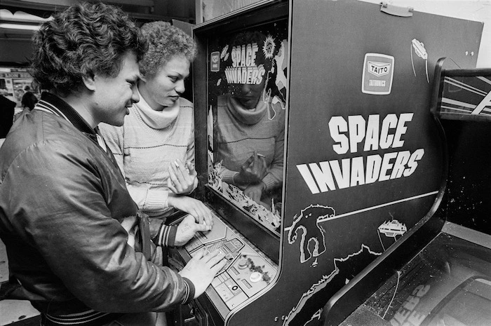 Young man and woman playing Space Invaders
