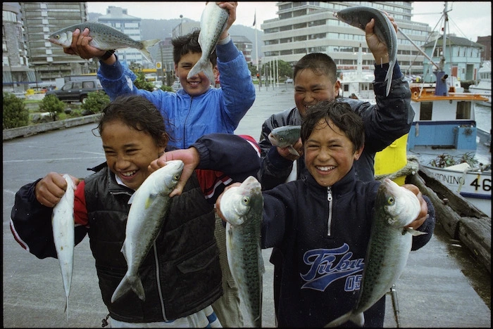 Four children hold up kahawai caught at Queens Wharf, Wellington - Photograph taken by Ross Giblin
