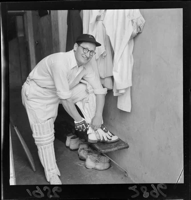 Unidentified cricket player, putting on his leg pads, Basin Reserve, Wellington