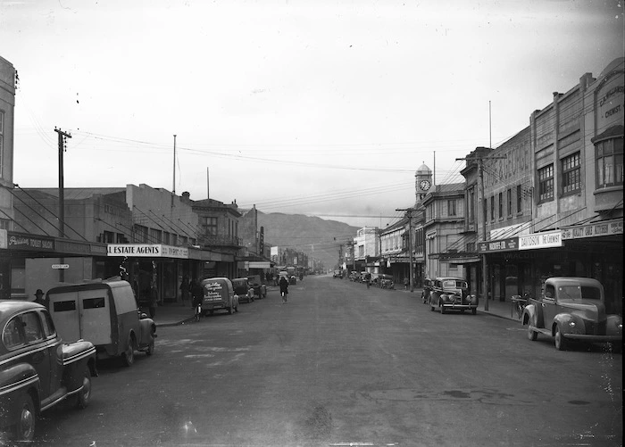 Looking down Jackson Street, Petone, close to Scholes Lane, with R W Short & Co and, a van advertising Madeline Cake Kitchen, on the left and the Quality Cake Kitchen, Davidson's chemist and Macduffs Ltd on the right
