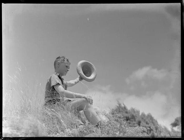 Summer Child Studies series, unidentified boy, sitting and waving his hat