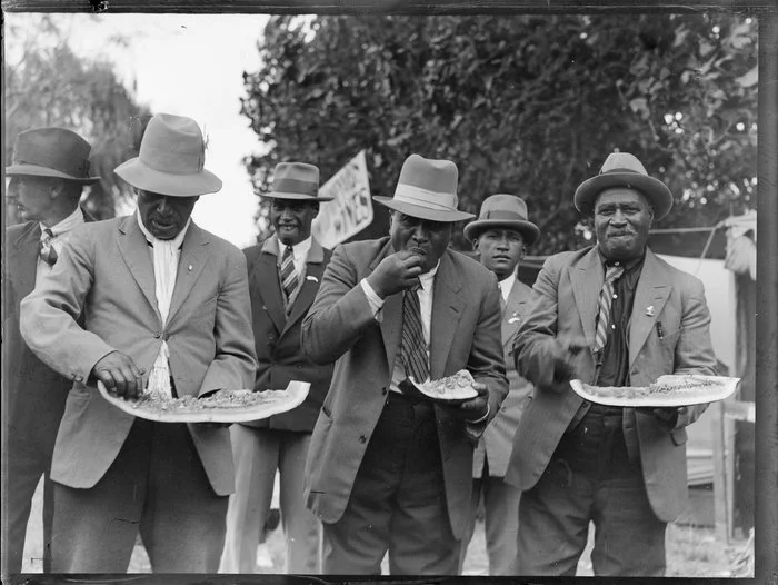 Group of Maori men eating watermelon, location unidentified