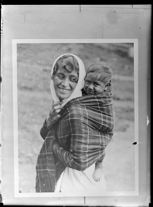Annie Ngauru Hoko (nee Downs) woman carrying a young child on her back wrapped in a blanket