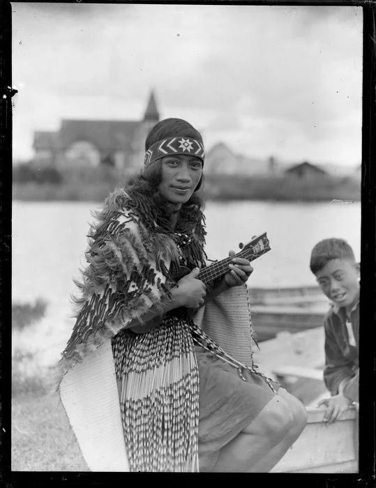 Māori woman dressed in piupiu and kakahu playing the ukelele, Ohinemutu, Rotorua