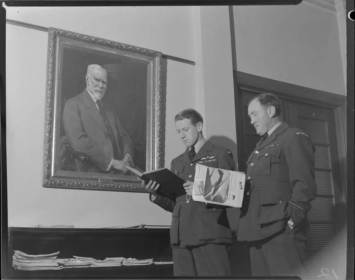 Flight Officers J Phillip and A Levy, Royal New Zealand Air Force, standing in front of a painting of Sir Henry Wigram