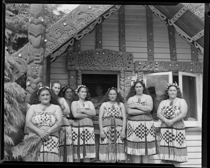 Group of Māori women outside a wharenui during Sir Peter Buck's visit, Horohoro