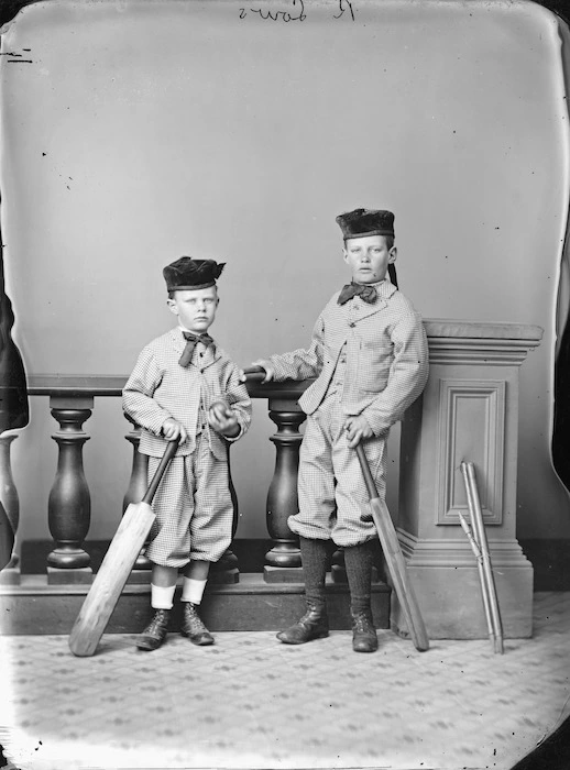 Two young boys of the Low family holding cricket bats