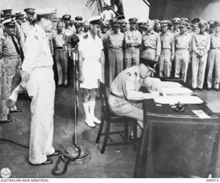 SURRENDER OF JAPANESE ABOARD USS "MISSOURI". AIR VICE MARSHAL I. ISITT, REPRESENTING THE DOMINION OF NEW ZEALAND, SIGNS THE INSTRUMENT OF SURRENDER WATCHED BY AN OFFICER OF THE ROYAL NEW ZEALAND ..