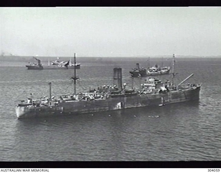 AERIAL STARBOARD QUARTER VIEW OF THE NEW ZEALAND CARGO VESSEL TONGARIRO WITH OTHER VESSELS OF A CONVOY. THE SHIP FURTHEST AWAY IS THE DEPERMING VESSEL HMS SPRINGDALE. NOTE THE 4 INCH GUN MOUNTED ..