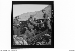 South Korea. c. 1950. Sergeant F. F. Smith of Auckland, New Zealand (centre), and Lieutenant N. Miller of St. Kilda, Vic, gun position officer, inspect the work of the gun crew as they furbish one ..