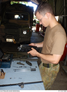 Private Julian Fisk, an Australian Defence Force mechanic and armourer, pulls apart a F88 Steyr rifle. eX de Medici incorporates elements of this photograph in the artwork 'AS/NZ Workshop' ..