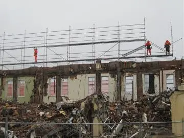 Workers removing scaffolding from side of Empire Hotel : Digital image